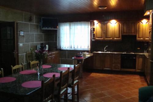 a kitchen with a table with pink mats on it at Casa do Nascente in Paredes do Rio