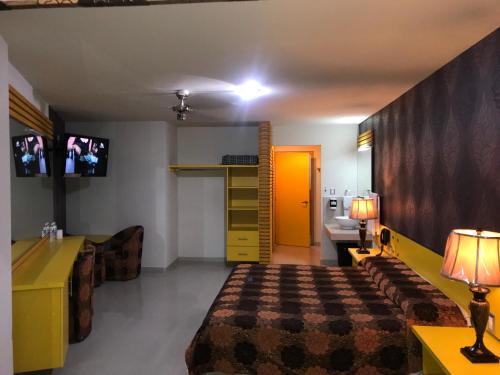 a hotel room with a bed and a yellow cabinet at Palacio Rojo Hotel Familiar in Morelia