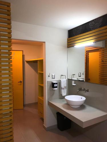 a bathroom with a sink and a large mirror at Palacio Rojo Hotel Familiar in Morelia