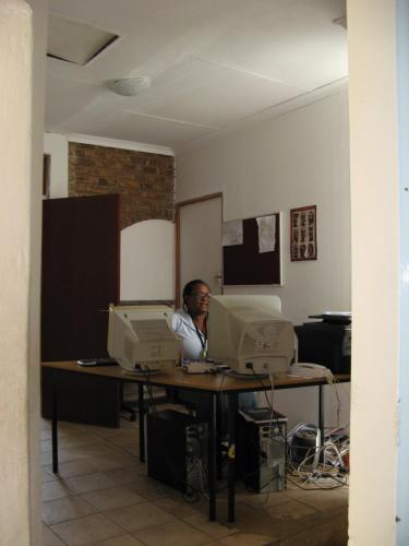 a man sitting at a desk with two computers at Fourways Johannesburg Hostel in Johannesburg