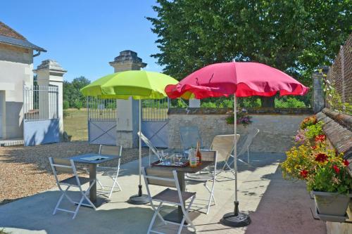 een tafel en twee parasols op een patio bij Château-Vert in Chaveignes