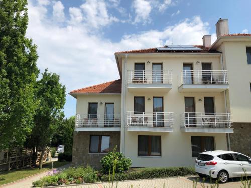 a building with a car parked in front of it at Jade Hotel-Ezüsthíd Hotel in Veszprém