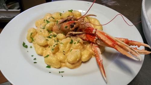 a white plate of food with shrimp and potatoes at Hotel Sicilia in Milan