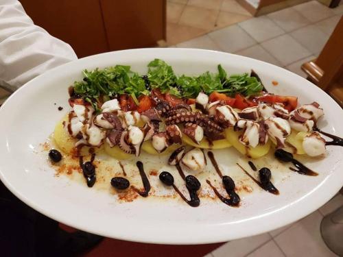 a plate of food with vegetables on a table at Hotel Sicilia in Milan