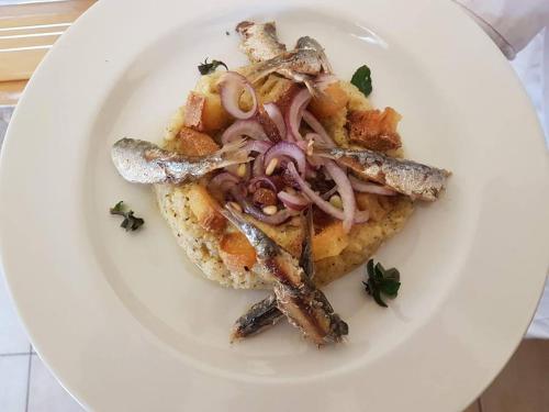 a white plate of food with someopus on it at Hotel Sicilia in Milan