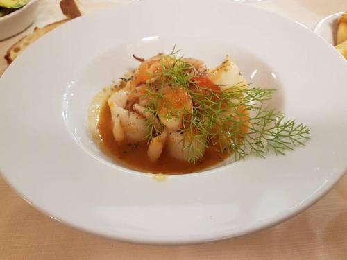 a white bowl of food on a white plate at Hotel Sicilia in Milan