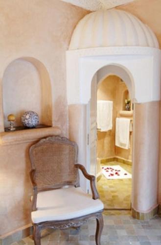 a chair sitting in a room with a bathroom at Riad Palais Des Princesses & Spa in Marrakesh