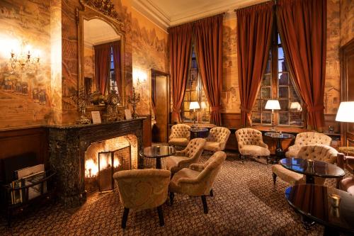 a living room with a fireplace and chairs and a mirror at De Tuilerieën - Small Luxury Hotels of the World in Bruges