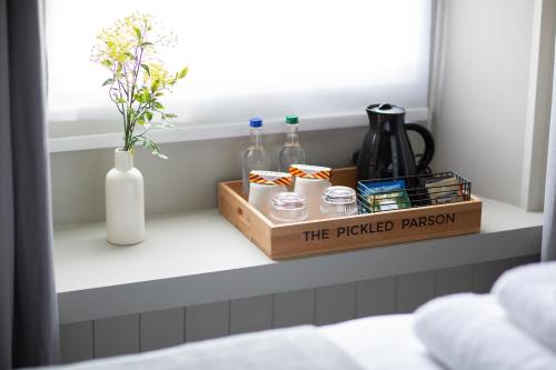 a shelf in a bedroom with a tray with bottles at The Pickled Parson of Sedgefield in Sedgefield