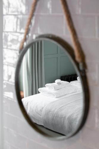 a mirror reflection of a bed with white towels at The Pickled Parson of Sedgefield in Sedgefield