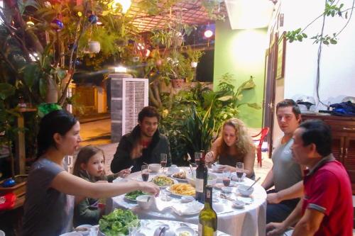 a group of people sitting around a table with food at Ngọc Sinh Homestay in Hoi An