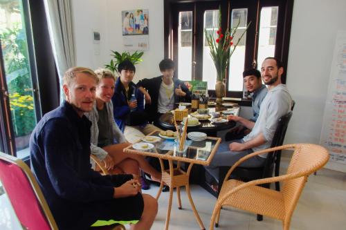 a group of people sitting around a table at Ngọc Sinh Homestay in Hoi An