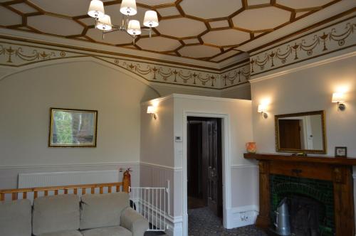 a living room with a couch and a fireplace at Hargate Hall Self Catering in Buxton