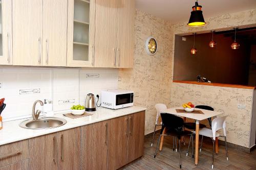 Una cocina con fregadero y una mesa con sillas. en Tbilisi Trinity Apartment, en Tiflis