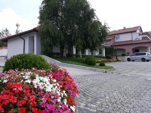 a bunch of flowers in a pot on a brick driveway at Zaara Estate Winery Hotel & SPA in Glavan