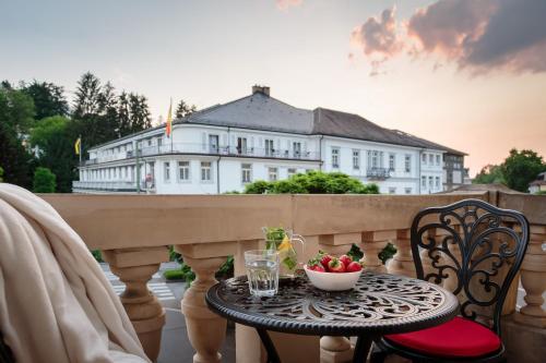 uma mesa com uma tigela de fruta numa varanda em Apartment am Kurpark em Baden-Baden