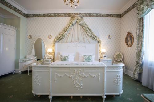 a bedroom with a white bed with a canopy at Hotel Der Kleine Prinz in Baden-Baden