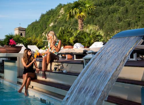 two women sitting on the roof of a boat in the water at Hotel Tosco Romagnolo in Bagno di Romagna