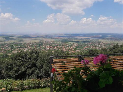 a bench on a hill with a view of a city at Zaara Estate Winery Hotel & SPA in Glavan