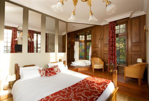 een slaapkamer met een groot bed en een rode deken bij Le Moulin De Connelles in Connelles