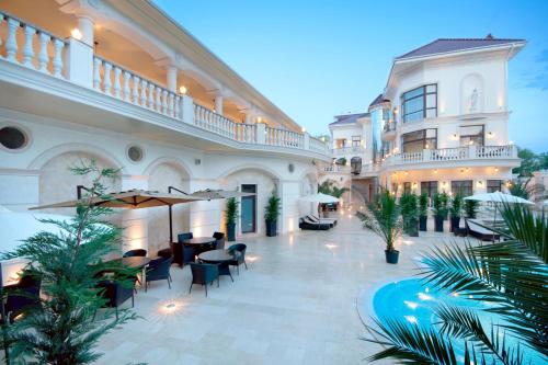 a courtyard of a building with tables and chairs at Villa Le Premier - Maestro in Odesa