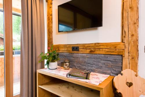 a wooden table with a television on a wall at Ferienwohnungen Erholungswelt Lechrefugium in Steeg