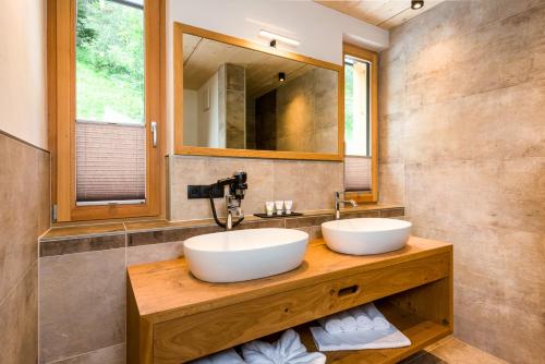 - 2 lavabos sur un comptoir en bois dans la salle de bains dans l'établissement Erholungswelt Lechrefugium, à Steeg