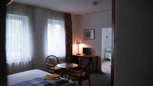 a room with a bed and a table and a desk at Landhaus Flughafen Messe in Freiroda