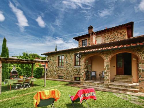 a stone house with a table and chairs in the yard at Tuscan style apartment in Lucignano near village with hill views in Lucignano