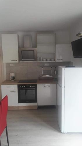 a kitchen with white cabinets and a refrigerator at Haus Piller in Bad Hofgastein