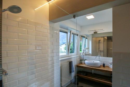 La salle de bains est pourvue d'un lavabo et d'un miroir. dans l'établissement Sofi apartment, à Chiavenna