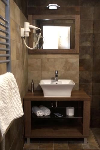 a bathroom with a sink and a mirror at Fitromax Sportpanzió Ajka in Ajka
