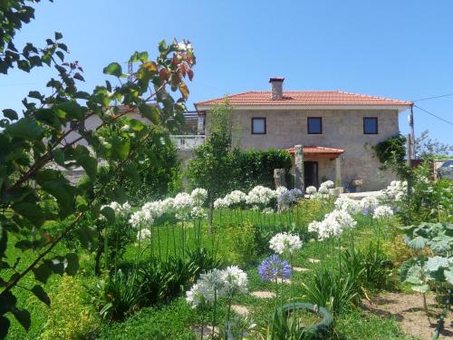 a garden with flowers in front of a house at Bernardes House in Castelo de Paiva