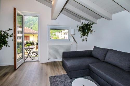 a living room with a couch and a large window at Sofi apartment in Chiavenna