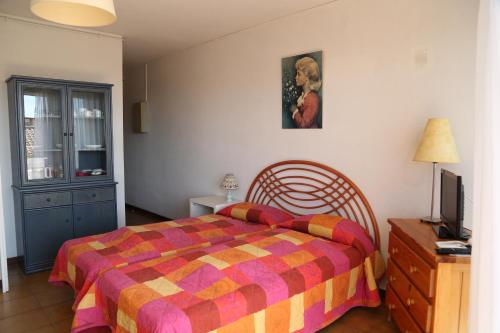 1 dormitorio con 1 cama y TV en Résidence Créole, en Valras-Plage