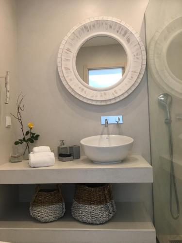 a bathroom with a sink and a mirror at Soltroia Beachouse in Troia