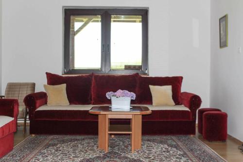 a living room with a red couch and a table at Green Forest Visoko in Visoko
