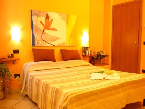 a bedroom with a large bed with yellow walls at Antica Corte in Lucca