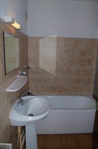 une salle de bain avec un lavabo et une baignoire dans l'établissement Résidence Créole, à Valras-Plage
