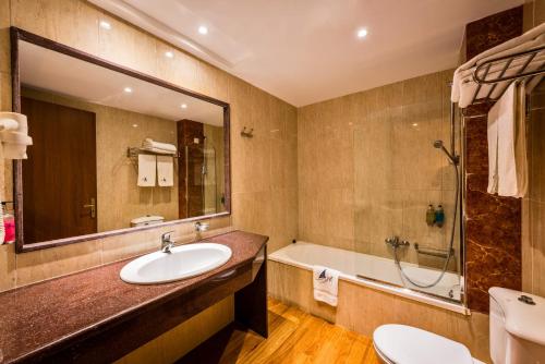 
a bathroom with a sink, toilet and bathtub at Mediterranean Beach Resort in Laganas
