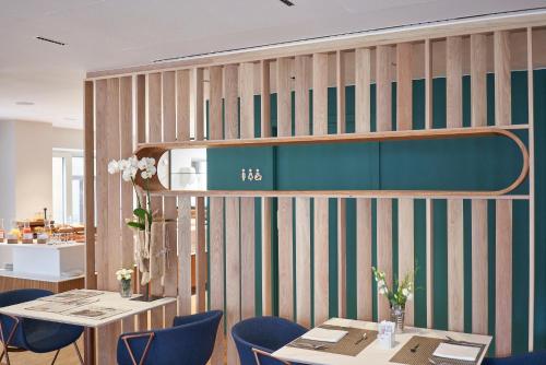 a restaurant with tables and chairs and a book shelf at Lasala Plaza Hotel - Adults Only in Donostia-San Sebastián