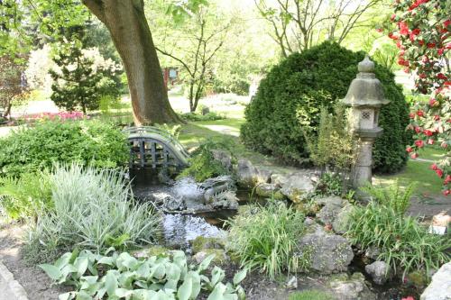 a garden with a bird bath and a stream at Kasino Hotel in Leverkusen