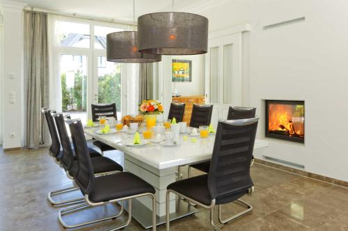 a dining room with a table with chairs and a fireplace at Lotsenstieg 11 in Ostseebad Karlshagen