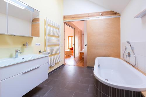 a bathroom with a tub and a sink at Dreigärten Brodowin in Brodowin