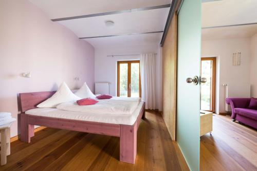 a bedroom with a bed with white sheets and red pillows at Dreigärten Brodowin in Brodowin