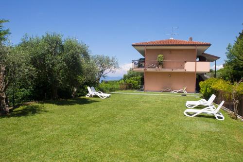 a house with a yard with two lawn chairs at Hotel Castello S. Antonio in Lazise