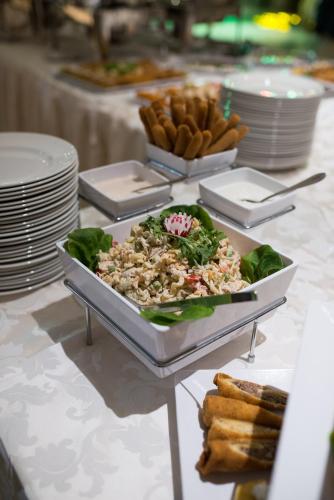a table with a plate of food on a table at Hotel Mellain in Tuzla