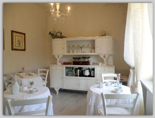 uma sala de jantar com duas mesas e um armário branco em Cascina Luvot em Melazzo