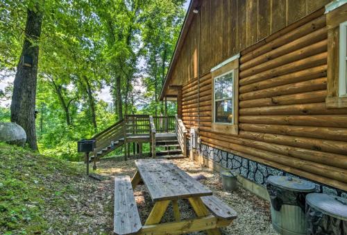 a wooden cabin with a picnic table outside of it at Nantahala Cabins in Bryson City