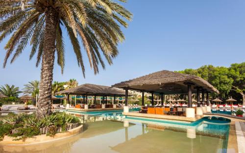 a resort with a palm tree and a swimming pool at Africa Jade Thalasso in Korba